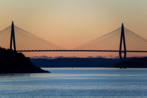 A scenic shot of the stunning Big Obukhov Bridge during the orange, warm sunset