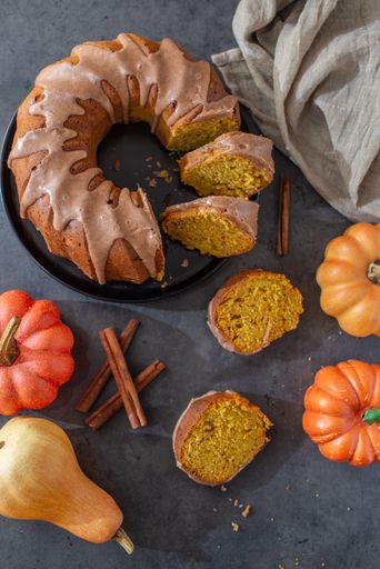 A vertical top view of a delicious pumpkin bundt cake with cinnamon frosting