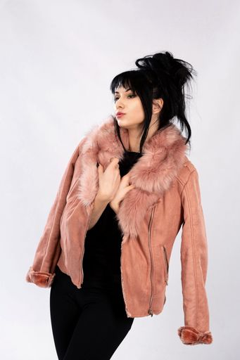 A vertical shot of a young Caucasian female in a warm coat posing on isolated white background