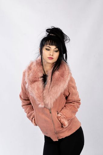 A vertical shot of a young Caucasian female in a warm coat posing on isolated white background