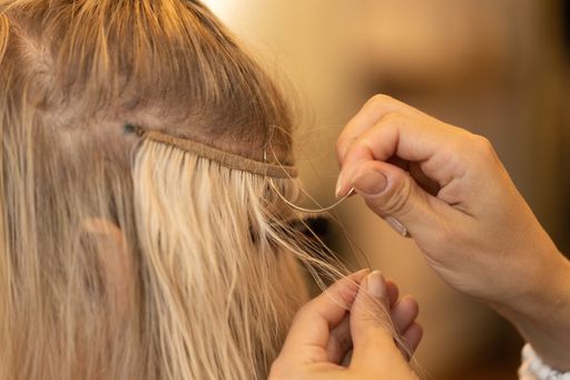 A closeup shot of the process of doing a hair extension
