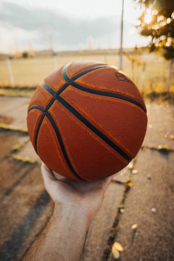 A vertical shot of a male hand holding a basketball