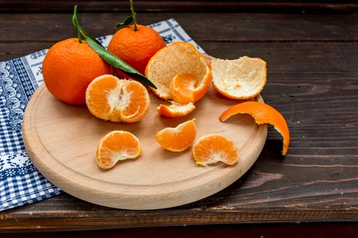 A closeup shot of peeled juicy tangerines on the wooden stand in the kitchen