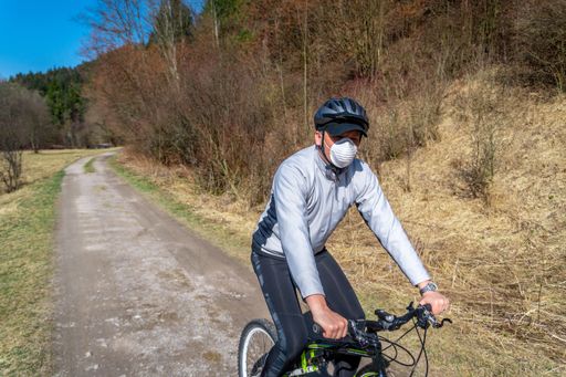 A view of a man riding  on his bicycle wearing a mask during the coronavirus  quarantine