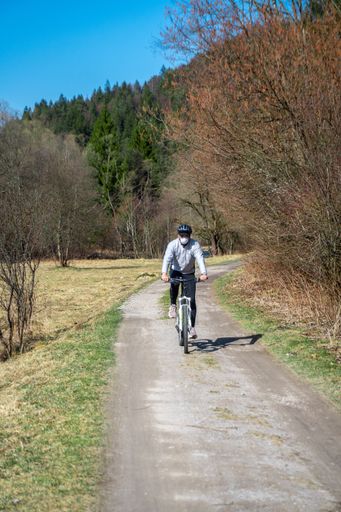 A vertical shot of a man riding  on his bicycle wearing a mask during the coronavirus  quarantine