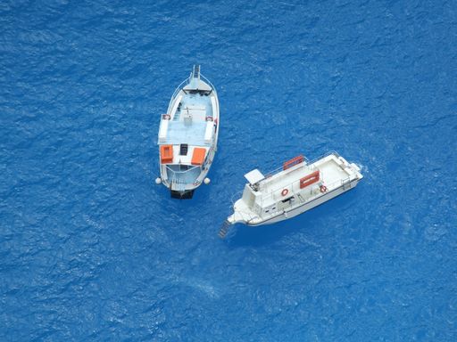 An aerial shot of two small modern boats on the beautiful blue seawater