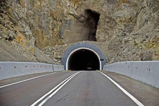 An asphalt road leading to the dark tunnel at daytime in the northern part of Chile