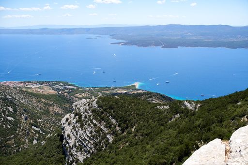 A scenic view of Zlatni Rat Beach in Bol, Croatia under a blue sky