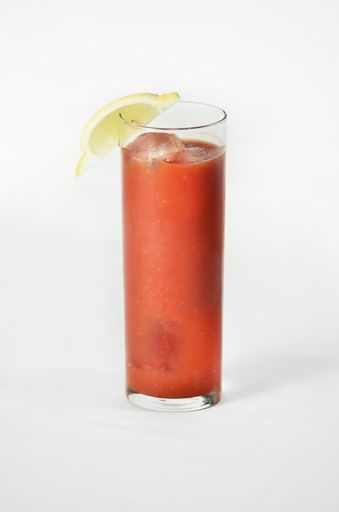 A vertical shot of a Bloody Mary cocktail with a lemon wedge on top with a white background