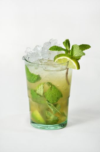 A vertical shot of a refreshing Mojito cocktail in a glass with a white background