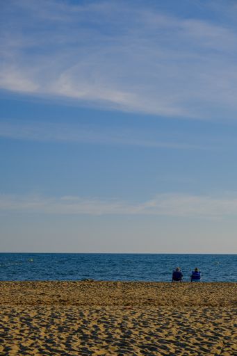 A beautiful view of two persons relaxing on the beach at Canela Island Ayamonte in Andalusia, Spain