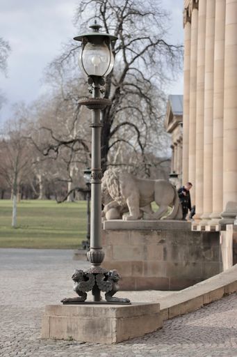 A vertical shot of a street lamp near a building
