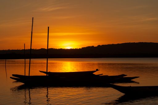 Silhouette at sunset of canoes docked in the grandiose Paraguacu river, located in the Brazilian state of Bahia.
