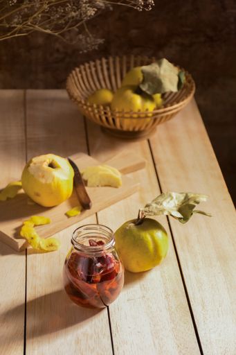 A vertical closeup of the quince on the wooden table. Still life fruits.
