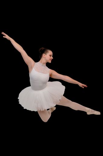 A professional woman ballerina dancing on a black background