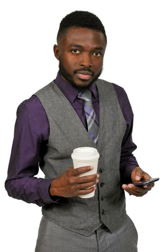 A vertical shot of an African American man holding a drink and a smartphone