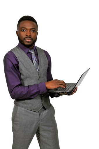 A vertical shot of an African American man holding a laptop