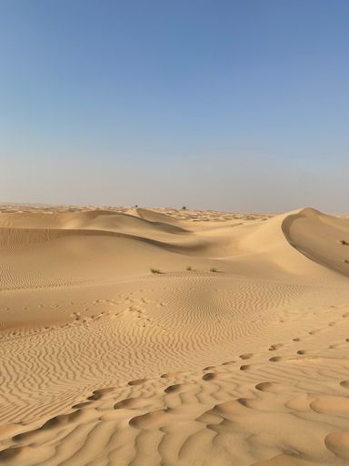 A vertical shot of the beautiful soft sands with steps in the desert with clear sky