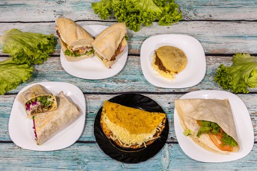 A top view of various types of sandwiches and wraps on plates