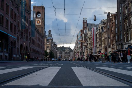 Pedestrian Crossing on the "Rode Loper" Damrak in Amsterdam with the Beurs van Berlage