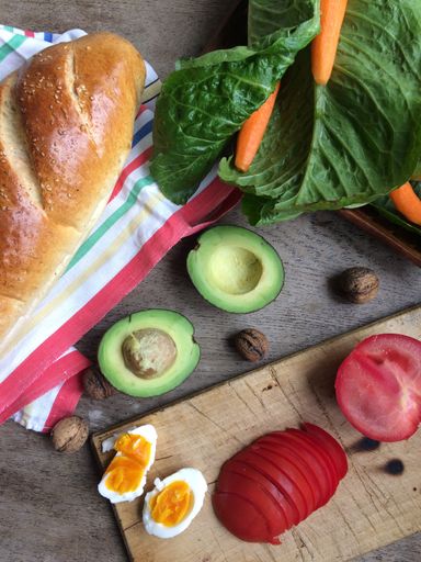 A high angle shot of  vegetables and bread on a wooden surface