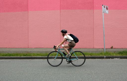 A young woman riding a bicycle in Vancouver, British Columbia, Canada