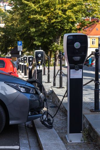 A gray electric Toyota connected to power station charger