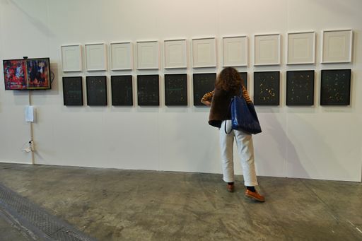 A back view of a woman looking at a painting during the contemporary art fair "Artissima" in Turin