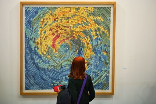 A back view of a girl looking at a painting during the contemporary art fair "Artissima" in Turin
