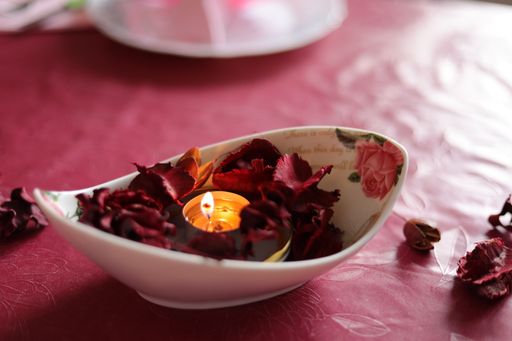 A closeup shot of an aromatic candle and flowers