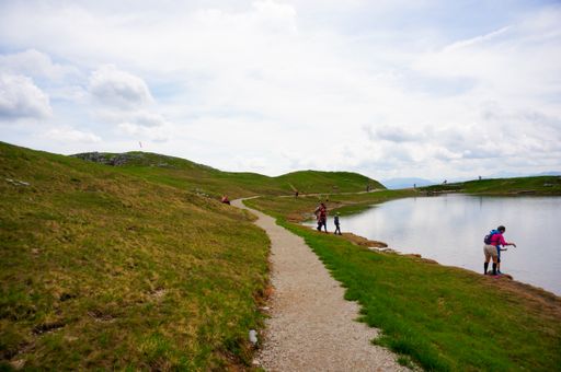A footpath and people next to a lake on the Alp mountain. Ausseerland, Austria