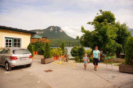 The woman and child walking close by a hotel and lake. Aultaussee, Austria