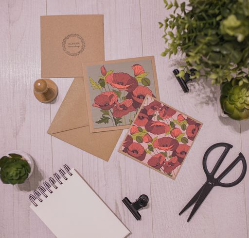 The enveloped with poppies scissors and a notebook on the table