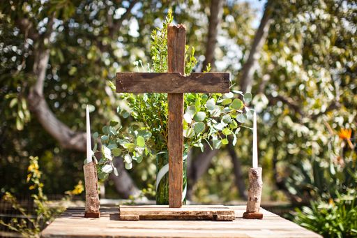 A shallow focus shot of a wooden cross with white candles on the sides
