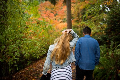 A shallow focus shot of male and female walking through the forest