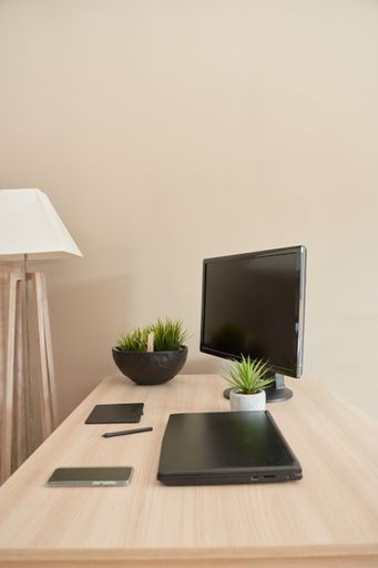 A vertical shot of a computer laptop and smartphone on the desk