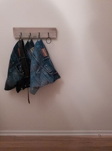 The jeans hanging on a wall hanger