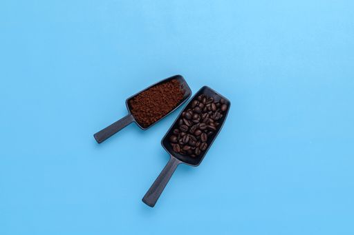 A top view of coffee beans on a blue background with a copy space
