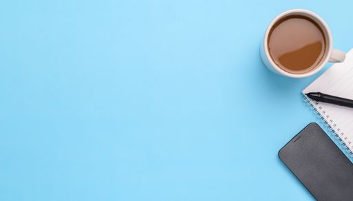 A top view of an Electronic pen, smartphone, book, coffee mug on blue background with a copy space