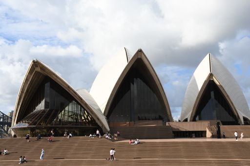 A scenic view of the Opera House against a blue cloudy sky in Sydney, Australia