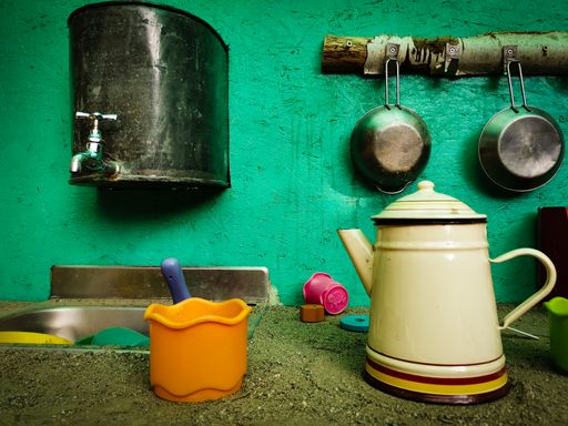 The rural kitchen. The colorful bowls, kettle, pans by the sink