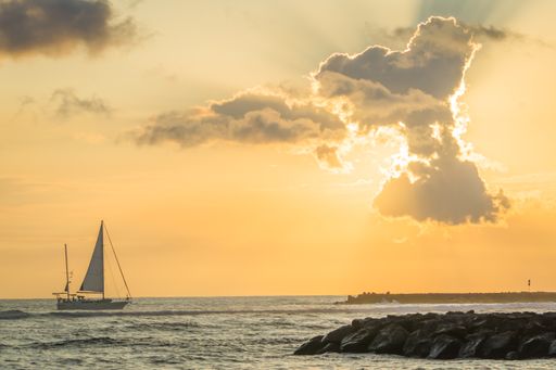 A sailing ship in the ocean during the sunset