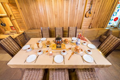 A high angle shot of a served food, plates, utensils and cups of tea on a dining table