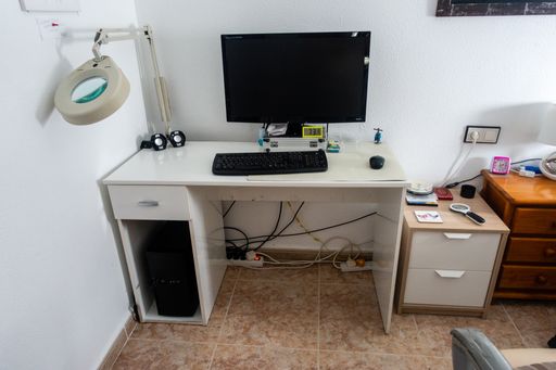 A beautiful shot of a desktop setup on a white table in a room