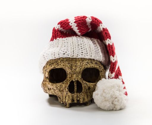 ape skull with christmas decorations and elf hat isolated on white background