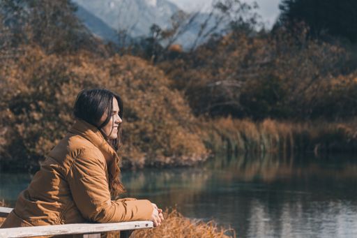 A young female admiring beautiful autumn nature at Zelenci nature reserve in Slovenia