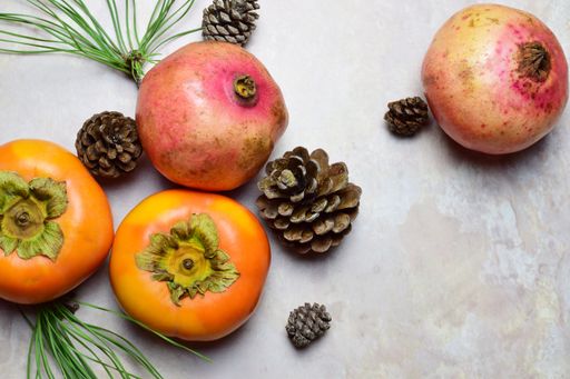 Autumn composition with fruits, pine needles, and cones in the grunge background