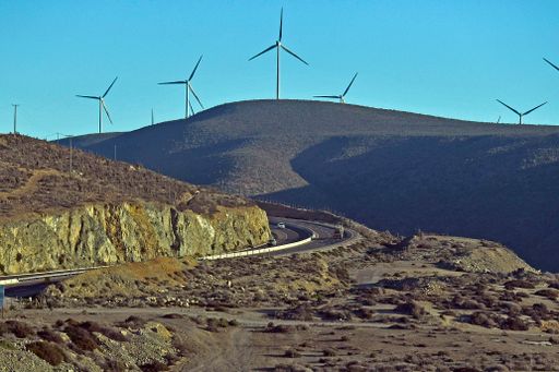 The blue sky over the field with rows of wind turbines on a sunny day in Chile