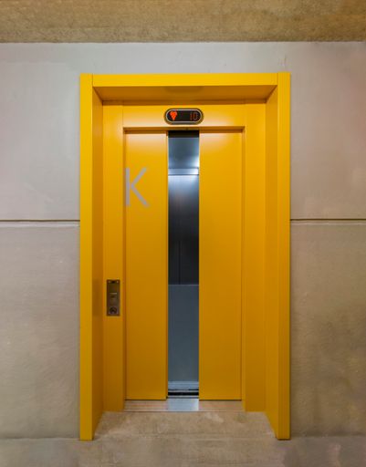 A closeup of a yellow-painted elevator door, Aachen, Germany