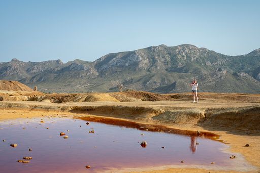 A young adventurous caucasian girl taking pictures in the mountains of the Mazarron desert